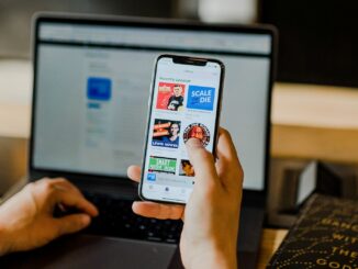 person using smartphone and laptop at the same time