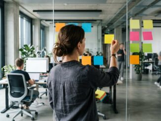 Product Owner ordnet Anforderungen als Klebezettel an einer Glaswand im Büro