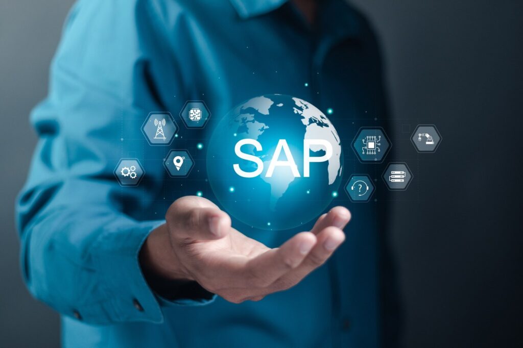 Person hält eine leuchtende Weltkugel mit dem Schriftzug SAP und Technologie-Symbolen in der Hand