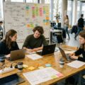 Gründungsteam arbeitet in einem hellen Gründungsraum einer Hochschule an einer Produktidee