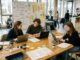 Gründungsteam arbeitet in einem hellen Gründungsraum einer Hochschule an einer Produktidee